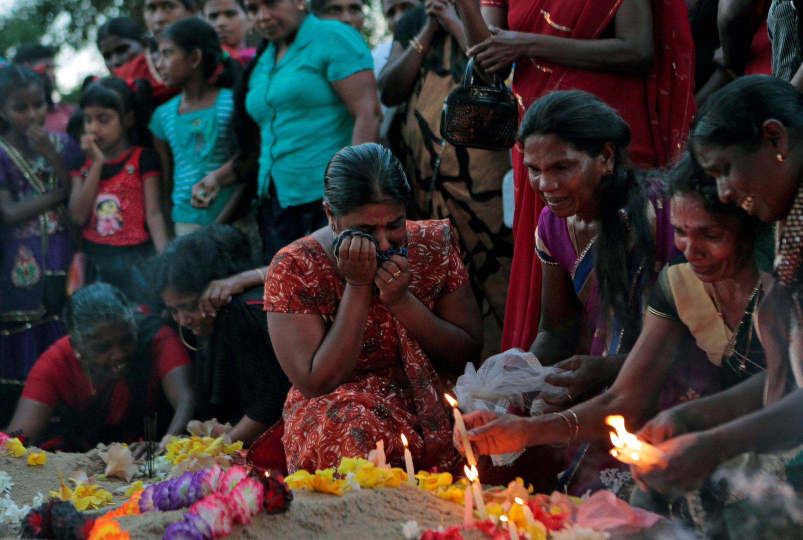 Women mourn at the graves of their relatives who died in 2009 during the last days of the war in Mullivaikkal, Sri Lanka, May 18, 2015.