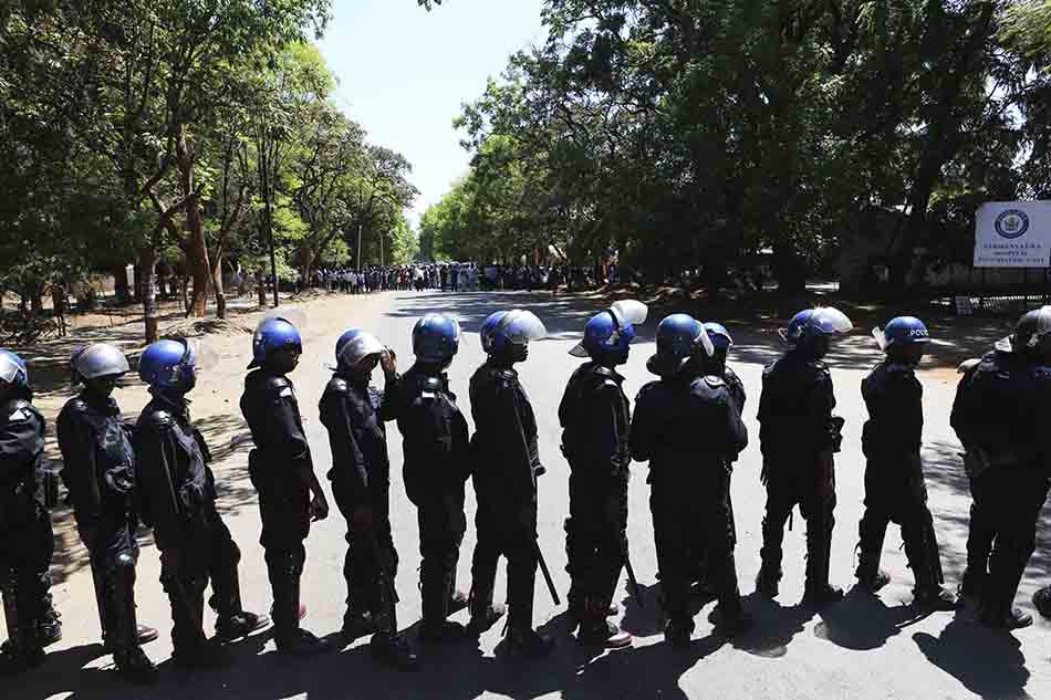 Armed riot police block the road as doctors attempt to march in Harare, Zimbabwe