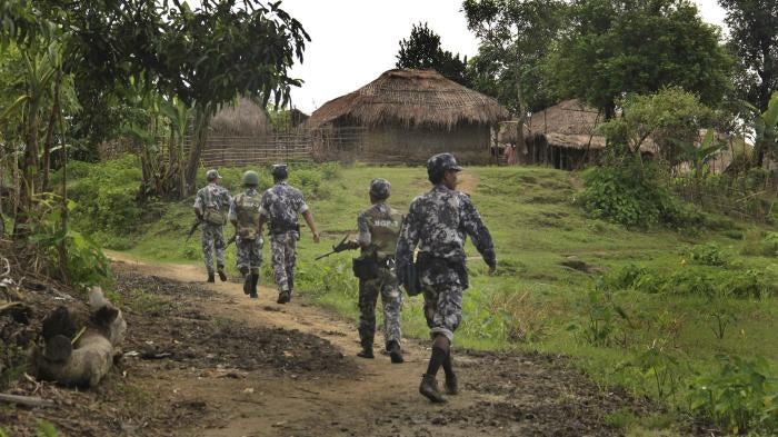 Myanmar border guard police officers walk along a path in Tin May village in northern Rakhine State, Myanmar, July 14, 2017.