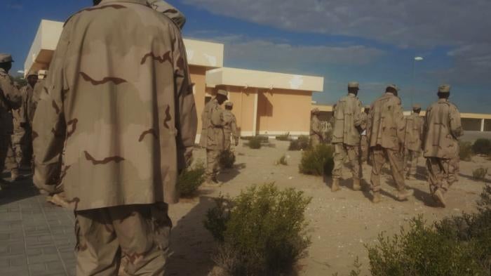 A group of uniformed men standing around a compound