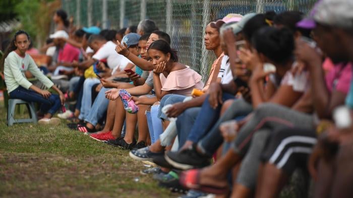 Familiares y amigos de migrantes venezolanos que fallecieron al hundirse el barco en el que viajaban a Trinidad y Tobago  esperan noticias sobre la recuperación de sus cuerpos, en Güiria, Venezuela, el 18 de diciembre de 2020.