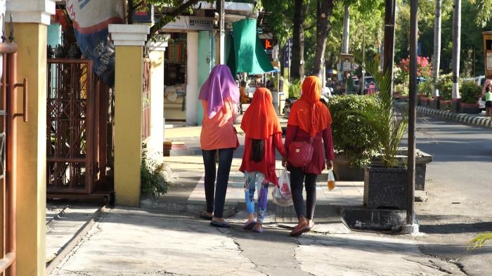 Young girls wearing jilbab walk away from the camera