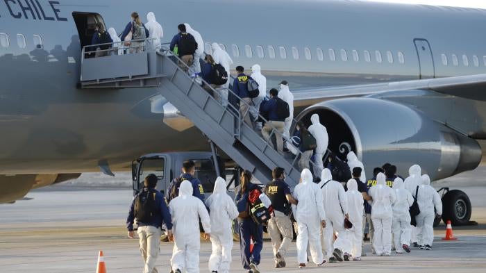 Venezuelan migrants board a plane as they are being deported from Chile, at the General Diego Aracena Aguilar International Airport in Iquique, Chile, on February 10, 2021. 