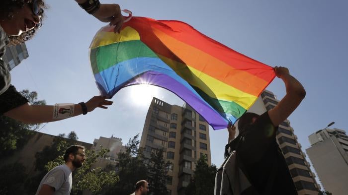 LGBT activists in Beirut, Lebanon shout slogans and hold up a rainbow flag as they march to demand equal rights in a country gripped by economic and financial crisis, June 27, 2020.