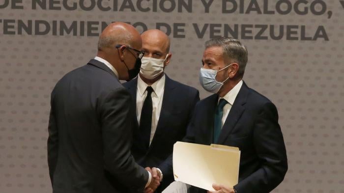 Jorge Rodriguez, left, representing the Maduro government, shakes hands with Venezuelan opposition delegate Gerardo Blyde Perez, in Mexico City, Friday, Aug. 13, 2021.