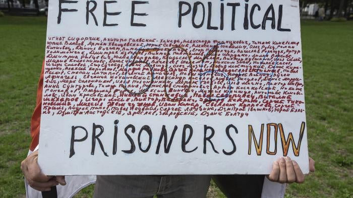 In The Hague, Netherlands, on August 7, a demonstrator holds a placard showing the names of some of those arbitrarily detained in Belarus for protesting against President Alexander Lukashenko, and calling for their release.