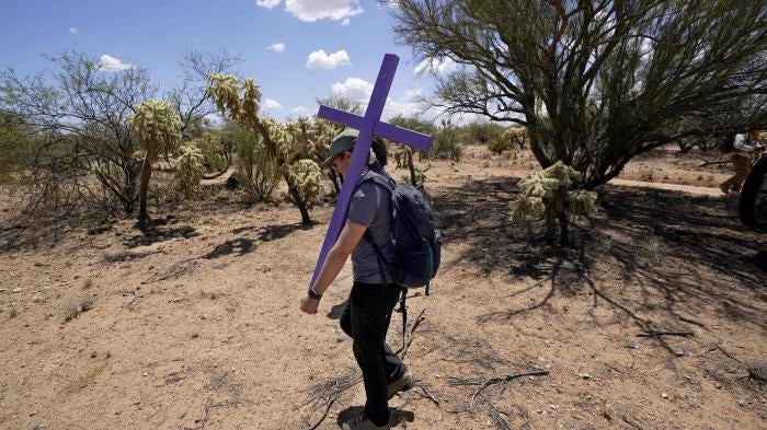 Alyssa Quintanilla, part of the Tucson Samaritans volunteer group, carries a cross, May 18, 2021, to be installed near Three Points, Arizona. The cross will be installed in the desert to commemorate the death of a migrant there. 