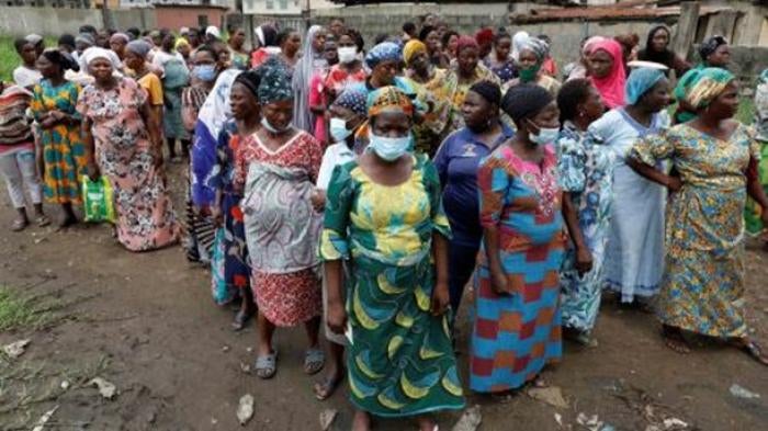 Women queue for food parcels during distribution by volunteers of the Lagos Food Bank Initiative, a nongovernmental organization, in a community in Oworoshoki, Lagos, Nigeria.