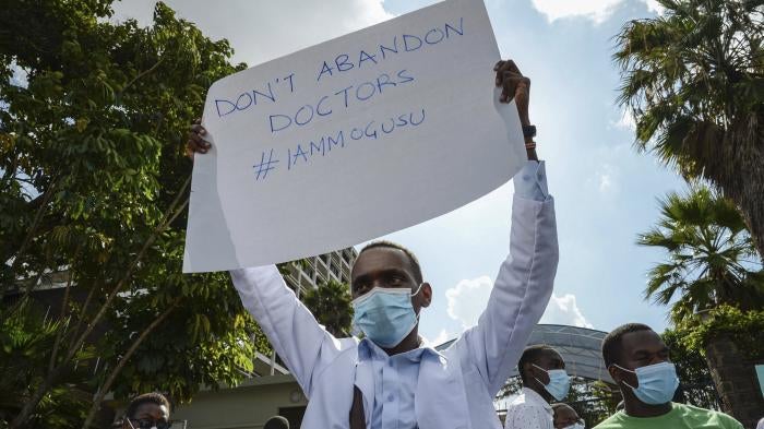 Healthcare workers protest outside the Ministry of Health headquarters in Nairobi, Kenya to honor one of their colleagues, Dr. Stephen Mogusu, a 28-year-old health worker who succumbed to Covid-19.