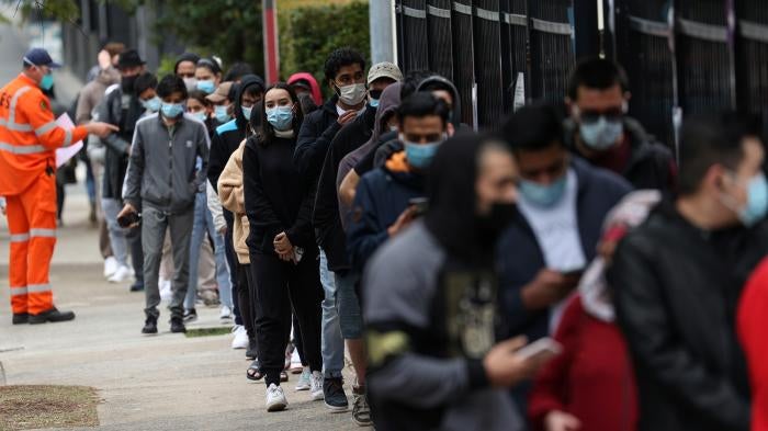 People wait outside a Covid-19 vaccination clinic in the Bankstown suburb during a lockdown in Sydney, Australia, August 25, 2021.