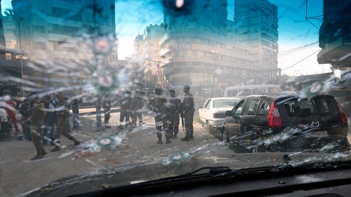 Lebanese army soldiers are seen through the bullet-riddled window of a car after deadly clashes erupted in Beirut, Lebanon, Thursday, Oct. 14, 2021.