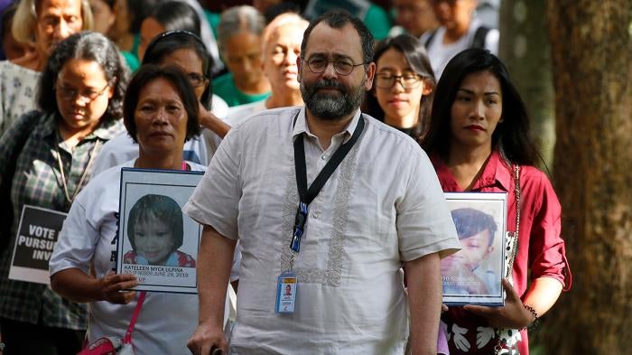 Commission on Human Rights Chair Chito Gascon, center, leads families of victims of alleged extrajudicial killings in the "war on drugs" in a march calling for an investigation by the UN Human Rights Council in Manila, Philippines, July 9, 2019.