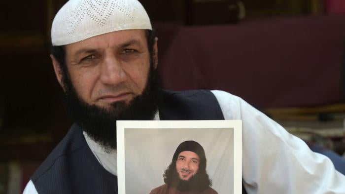 Afghan refugee Roman Khan at a refugee camp near Pakistan's northwestern city of Peshawar in September 2020, displays a photograph of his brother Asadullah Haroon, who is detained at the Guantanamo Bay detention center.