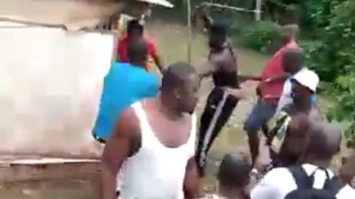 A blurry screenshot from a video showing a mob of men 