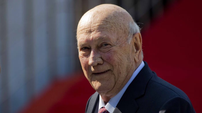 An elderly man smiles at the camera