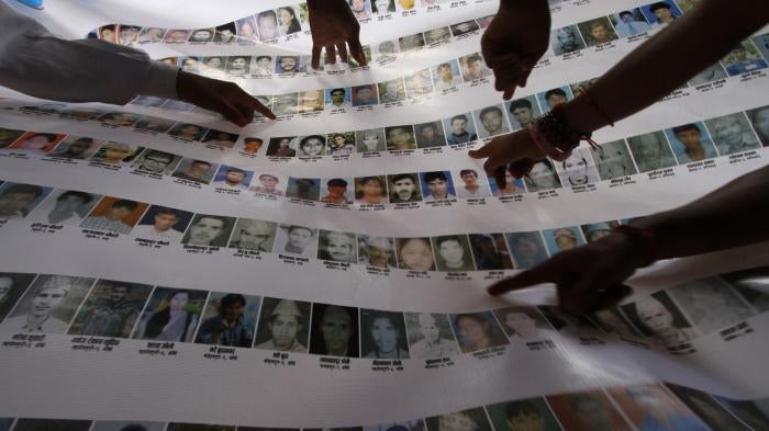Nepalese human rights activists and relatives point to photographs of disappeared persons at an event to mark the International Day of the Disappeared, in Kathmandu, August 30, 2011.