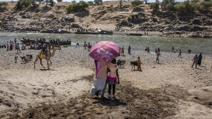 Refugees who fled the conflict in Ethiopia's Tigray region arrive on the banks of the Tekeze River on the Sudan-Ethiopia border, in Hamdayet, eastern Sudan, November 21, 2020.