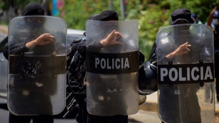 Riot police stand guard outside the house of Cristiana Chamorro, former director of the Violeta Barrios de Chamorro Foundation and opposition presidential candidate, in Managua on June 2, 2021, the day Nicaraguan police raided her home without a warrant and placed her under house arrest.