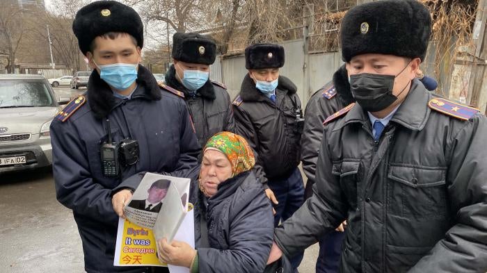 Police detain Khalida Akytkhan outside the Chinese Consulate in Almaty, Kazakhstan, where relatives of people detained or disappeared in Xinjiang, China have been protesting for over 300 days.