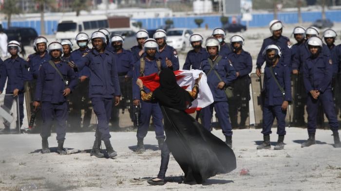 An anti-government protestor gestures in front of police as demonstrators re-occupy Pearl roundabout on February 19, 2011 in Manama, Bahrain. Ten years after the anti-government protests, virtually all opposition has been quashed.