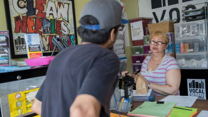 Evelyn Milan, right, prepares a package with sterile injecting equipment for a member at VOCAL-NY's headquarters in the Brooklyn borough of New York, June 3, 2018. 