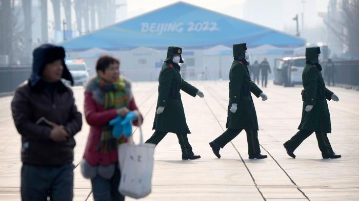 Chinese paramilitary police walk on the Olympic Green at the 2022 Winter Olympics in Beijing