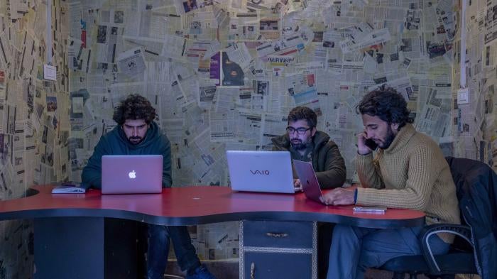 Fahad Shah, right, editor-in-chief of the Kashmir-based news website, The Kashmir Walla, in his office in Srinagar, India, January 21, 2022.