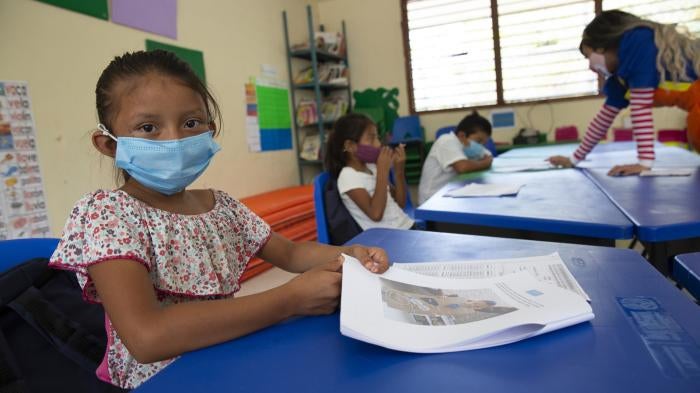 A child wears a face mask in a classroom
