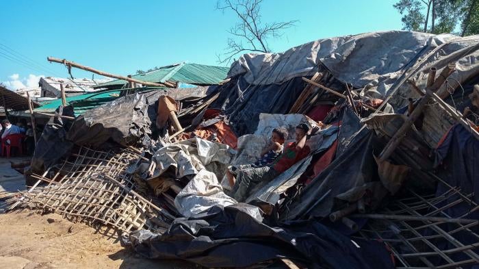 Rohingya refugees lie on a razed shop demolished by authorities in the Kutupalong camp in Ukhia, Bangladesh, December 10, 2021. 