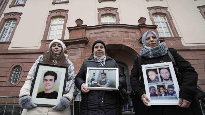 3 women hold framed photographs