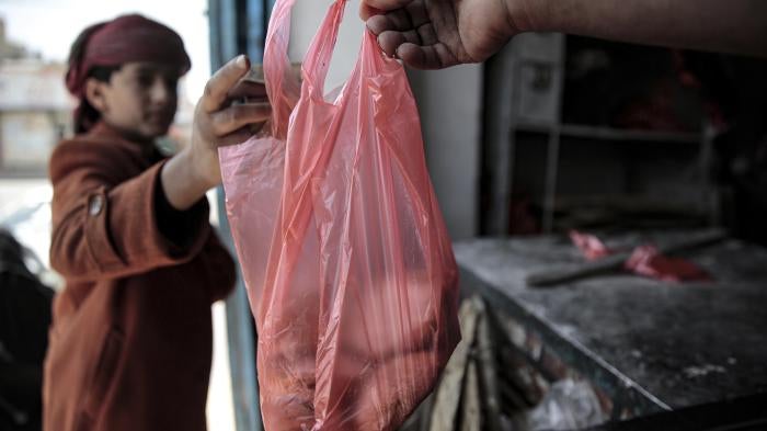 A boy is handed a bag of bread