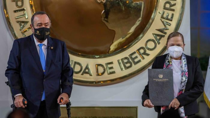 El presidente Alejandro Giammattei y la procuradora general de Guatemala, Consuelo Porras, posan para una foto tras la juramentación de Porras para otro mandato de cuatro años, en el Palacio Nacional en Ciudad de Guatemala, el 16 de mayo de 2022. 