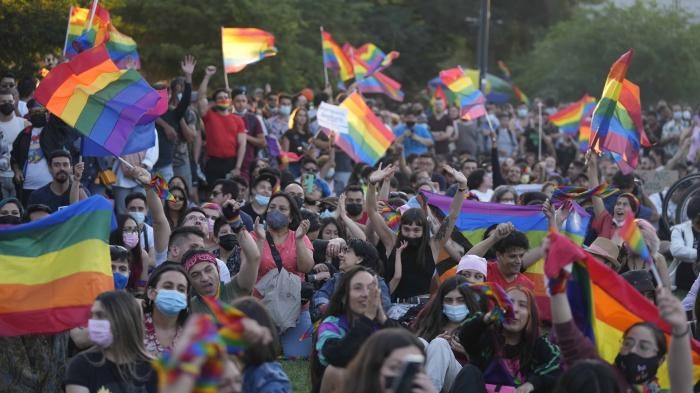 Chileans celebrate after lawmakers passed legislation legalizing marriage for same-sex couples, in Santiago, Chile, Tuesday, Dec. 7, 2021. (AP Photo/Esteban Felix).