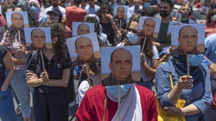 Demonstrators carry pictures of activist Nizar Banat during a protest in the West Bank city of Ramallah on the same day he was beaten to death in Palestinian Authority custody, Thursday, June 24, 2021.