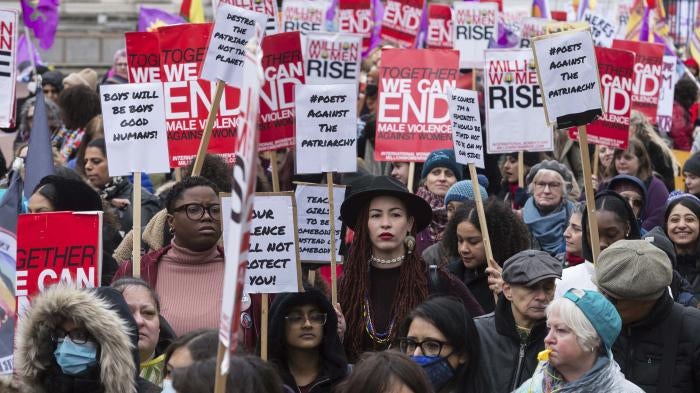 Women hold placards at the Million Women Rise march in London ahead of International Women's Day on March 05, 2022. 