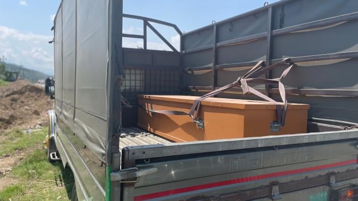 A casket lies on the back of a truck