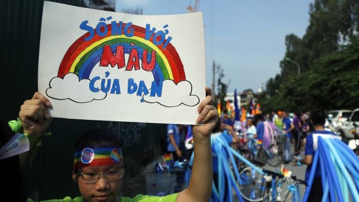 A cyclist holds up a poster reading in Vietnamese, "Shine your true colors," ahead of a bike rally in Hanoi, Vietnam, September 24, 2017. 