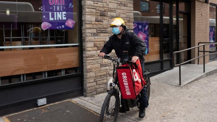A delivery man bikes with a food bag from Grubhub in New York, April 21, 2021