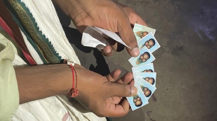 Son showing photos of father who died in Qatar
