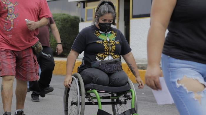 Una mujer discapacitada circula en su silla de ruedas en una calle de Iztapalapa, en Ciudad de México, en junio de 2021.