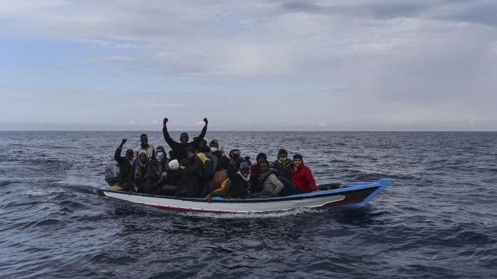 Migrants aboard on a wooden boat in the Mediterranean Sea.