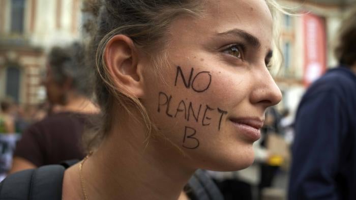 A protester with "NO PLANET B" written on her face attends a climate change demonstration in Toulouse, France, September 23, 2022.