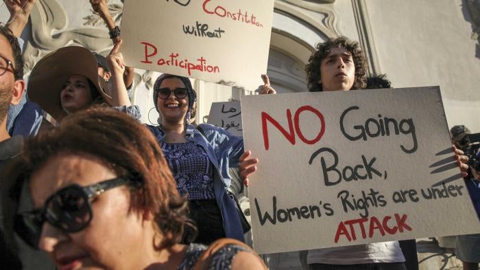 A Tunisian protester holds up a sign that reads, “No going back, women's rights are under attack,” during a protest against president Saied on Avenue Habib Bourguiba in Tunis, on July 22, 2022.