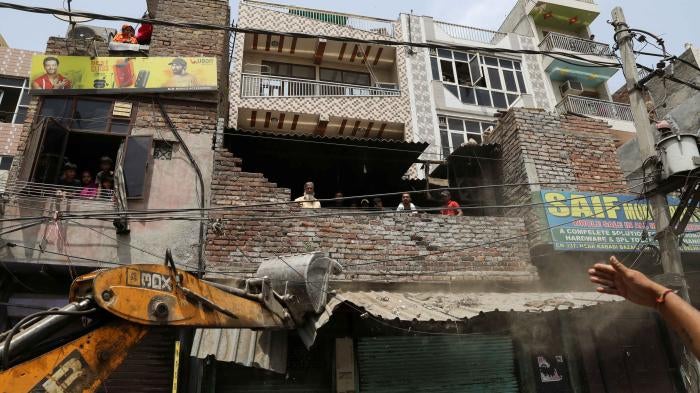A bulldozer demolishes a shop entrance in Jahangirpuri, in New Delhi, India, April 20, 2022.