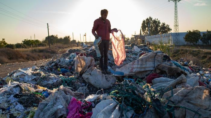 A man collects items from an illegal dump on November 29, 2020 in Adana, southern Turkey.