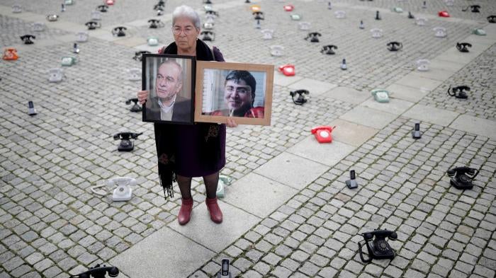Fadwa Mahmoud holds portraits of her son and husband, who disappeared in Syria in 2012, in Berlin, Germany. 