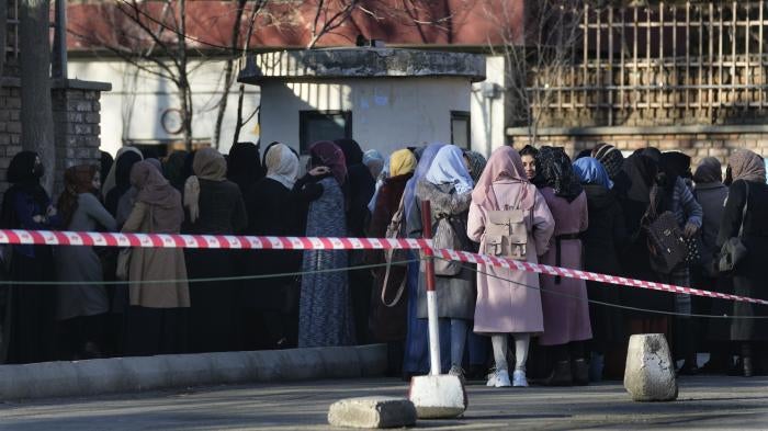 Afghan female students line up at one of Kabul University's gates