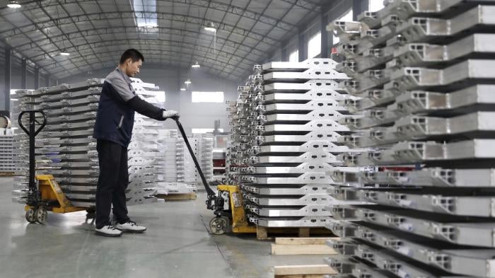 A worker moves aluminum auto parts in central China's Anhui province.