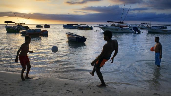 Children playing at sunset at Trou aux Biches in Mauritius. 