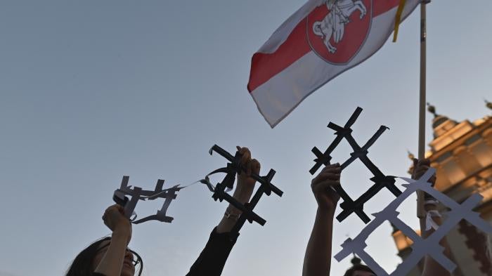 Protesters display broken paper prison bars representing the Belarusian population in prisons and the lack of freedom in Belarus, in Krakow, Poland on August 9, 2022. 